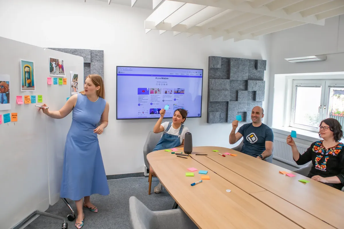 A diverse team collaborates in a modern office space, engaging in a creative presentation.