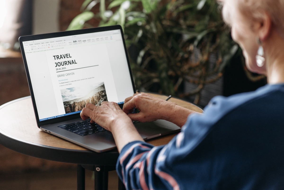Persona che scrive su laptop con documento aperto