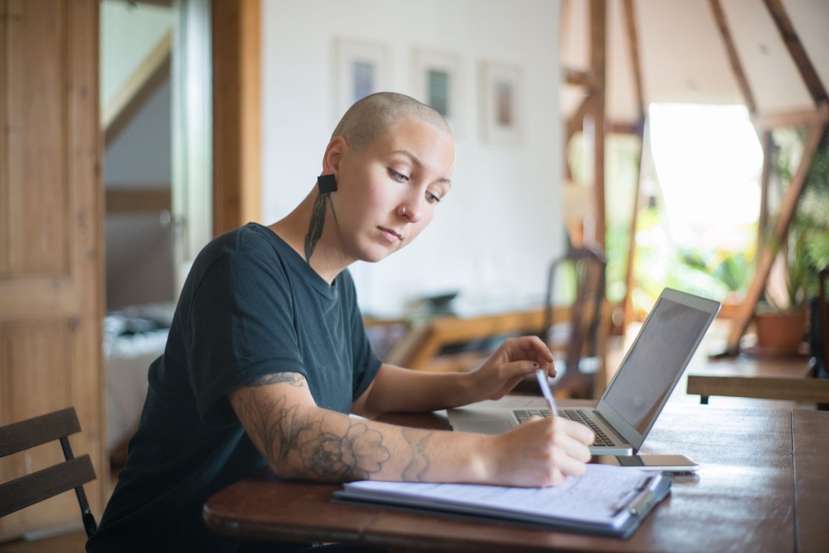 person looking at computer with notebook open