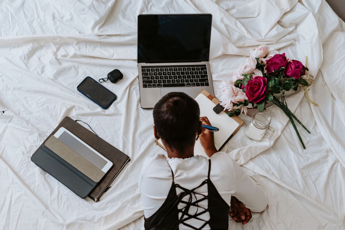 Persona che lavora su laptop con notebook aperto